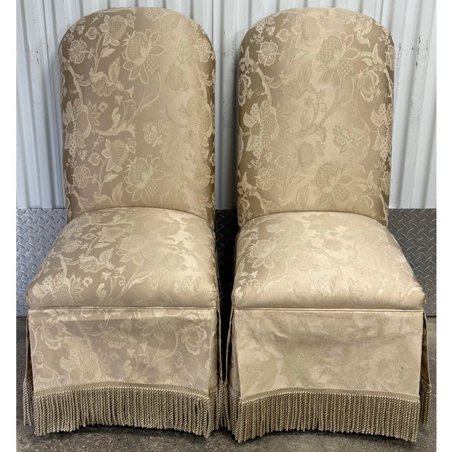 Beautiful pair of parsons chairs with skirted bottom embellished with fringe detail and elegant champagne color...