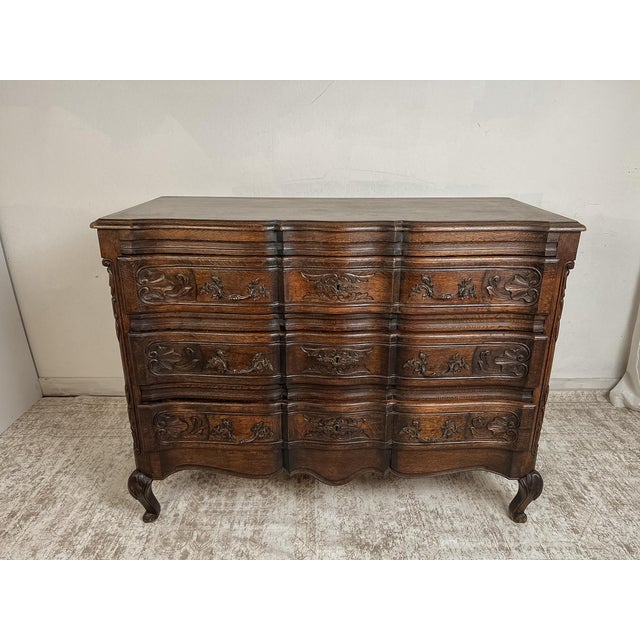 Crafted from solid French oak, this vintage chest of drawers showcases graceful serpentine drawer fronts, hand-carved...