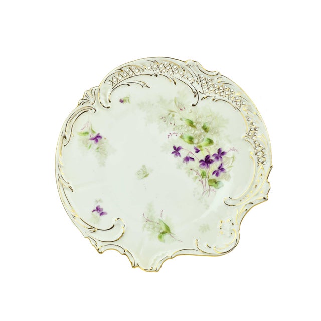 This exquisite Early 20th Century Bavaria plate set epitomizes vintage elegance with its delicate artistry and intricate...