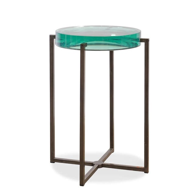 The Holly Hunt Studio Lens Side Table is a study in balance and material contrast. A thick, green-tinted glass top appears...