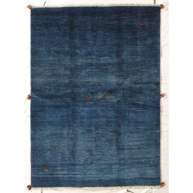 Vintage Hand-knotted Persian Lori Gabbeh rug featuring a deep indigo field with subtle tonal variation and a sparse...