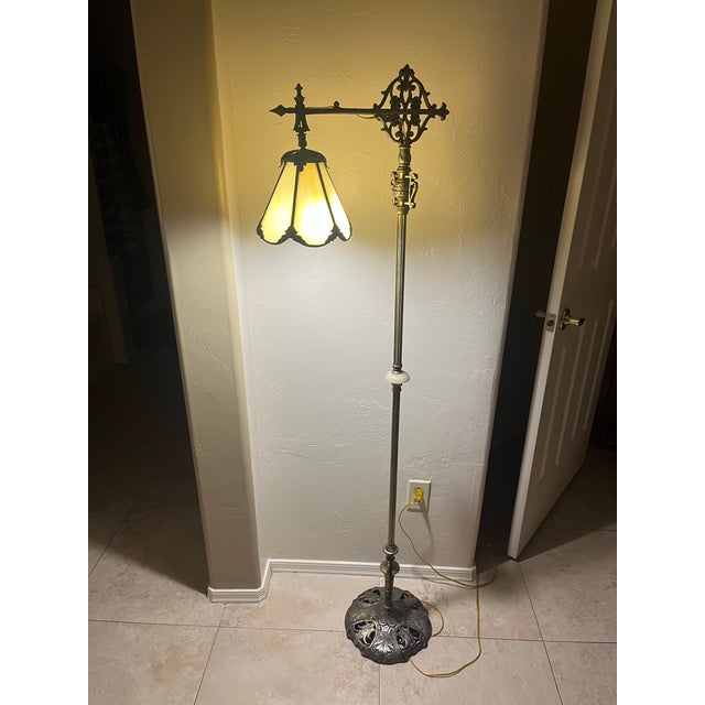 This item is a vintage Tiffany-style bridge arm floor lamp, characterized by its decorative metal base and leaded stained...