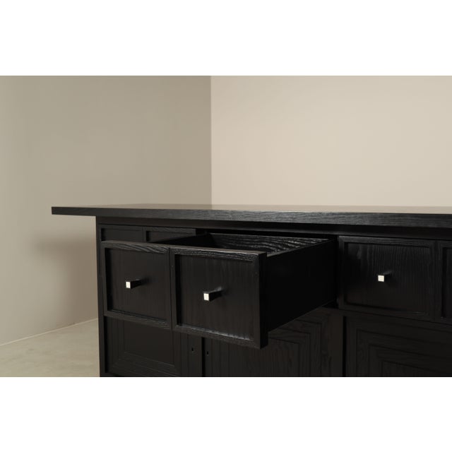 The large cabinet is built as a strongly horizontal composition, with four wide drawers above four substantial panelled...