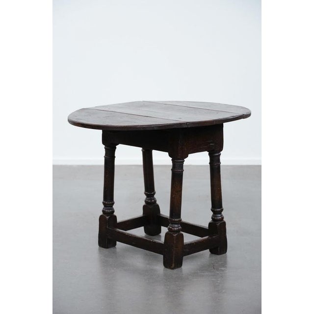 Offered for sale is this charming and unique antique English classic drop-leaf side table/joint stool made of oak from the...
