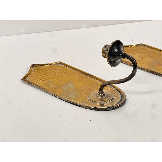 Beautiful pair of vintage wall sconces in hammered brass, dating from the 1960s. These mid-century pieces feature a warm,...