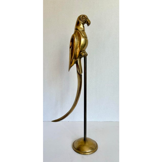 This is a striking mid-20th century brass parrot sculpture, mounted on a slender stand with a round brass base and dating...