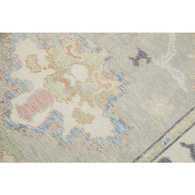 This modern Turkish Oushak rug is a stunning piece of art that has been handwoven using traditional techniques by skilled...