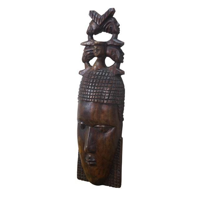 Vintage African tribal head mask featuring a matriarch wearing a headdress of her family. Dimensions: 7.75" x 3.5" x 25.5"...