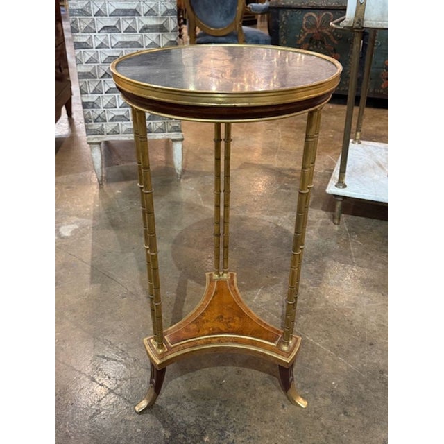 This 19th Century Louis XVI bamboo form side table with an inset marble top is a luxurious and elegant piece of furniture....