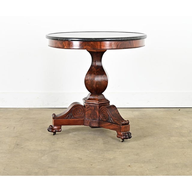 A gorgeous French marble-top gueridon table from the Restauration period (19th century). This round pedestal table is...
