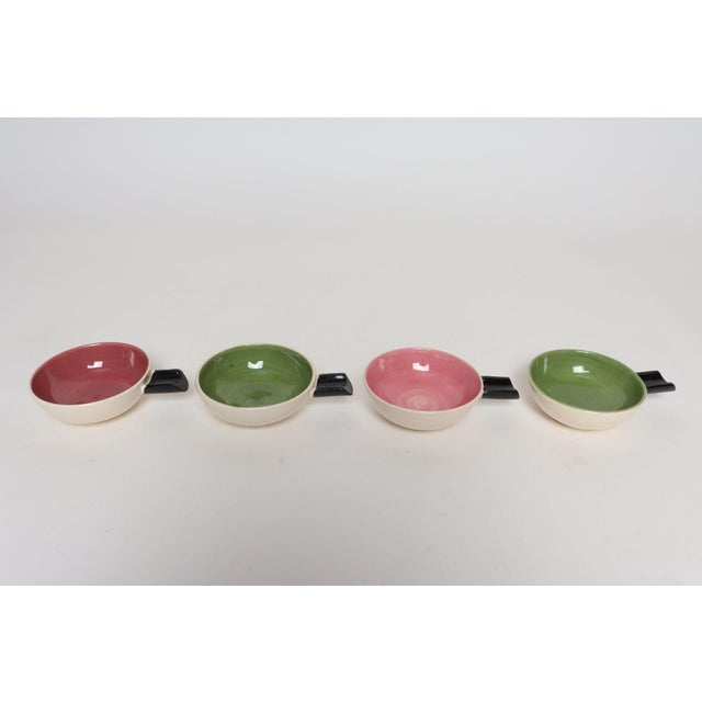 Set of four small studio pottery ramekins/handled bowls by Charles Wilton (ca. 1950s, Australia). Features glazed vessels...