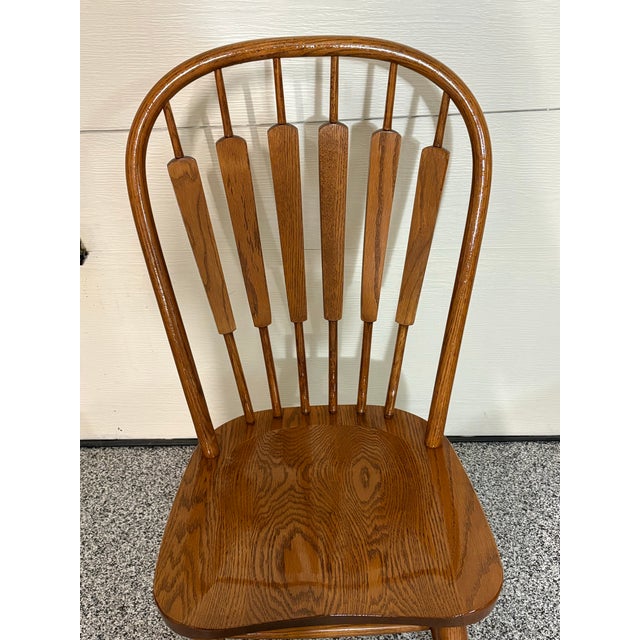 A striking set of four vintage arrow-style back Windsor dining chairs crafted from sturdy, solid oak. This beautifully...