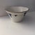 This off-white small ceramic bowl with crackle glaze features angled sides and is decorated with a charming French Blue...