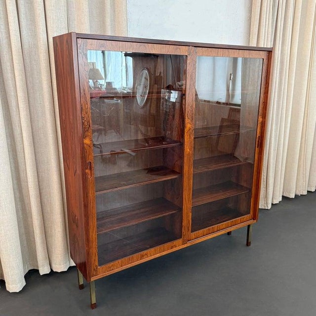 This Danish Mid-Century Modern rosewood display cabinet bookcase was designed by Poul Hundevad circa 1960s. The cabinet...