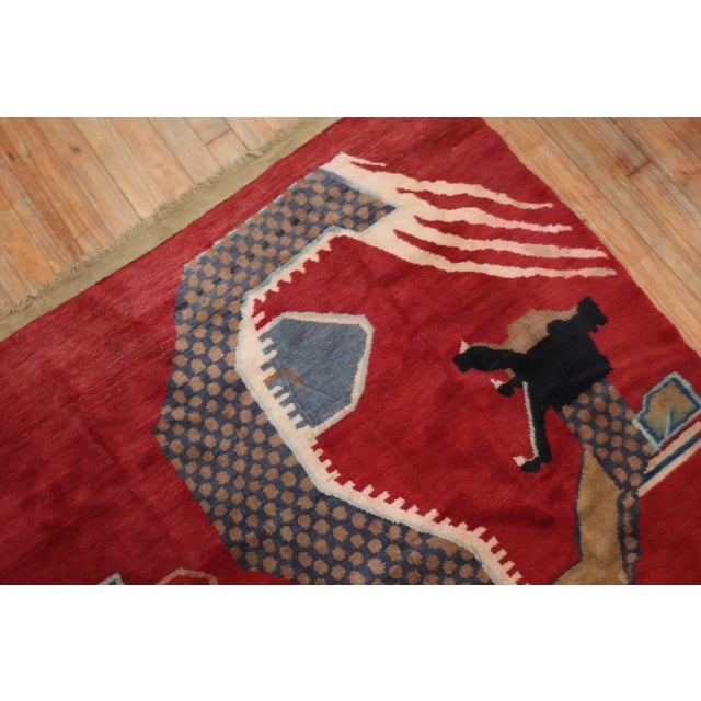 A 3rd quarter of the 20th-century Chinese rug with a dragon motif on a dark red field Size: 4' x 7''.