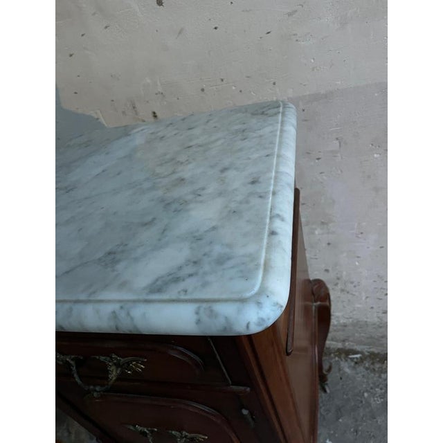 Introduction elegant french louis xv–style bedside cabinet featuring a solid white marble top. This refined piece dates...