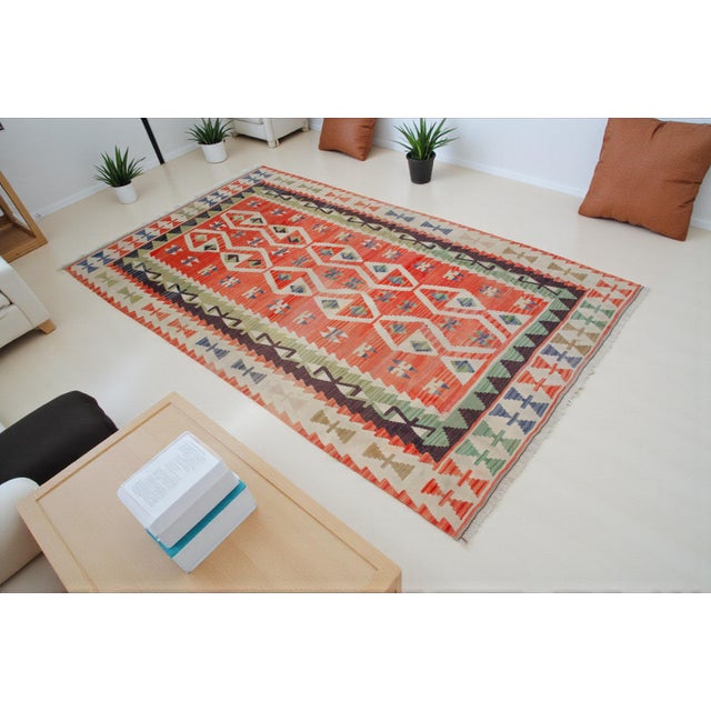 Crafted in Anatolia, this vintage Turkish Oushak kilim showcases the durable natural wool and crisp flat-weave...
