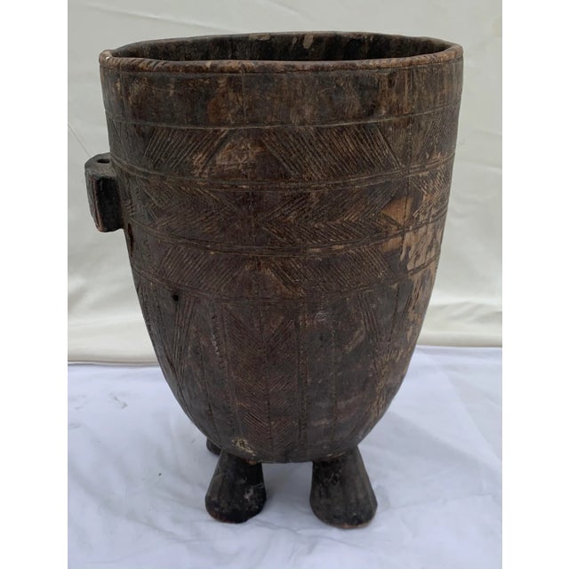 Antique hand carved 4-legged tribal wood vessel. Intricate linear pattern design with handle for rope or hook. Inside...