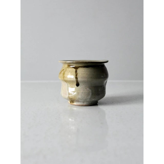 Vintage studio pottery vase with a hand-crafted, one-of-a-kind character. This ceramic catchall jar features a soft gray...