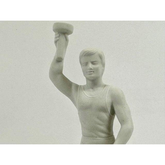 A souvenir from the 1936 Olympic Games. Statue is made out of fine white bisque, the base bears the Olympic Rings, is...