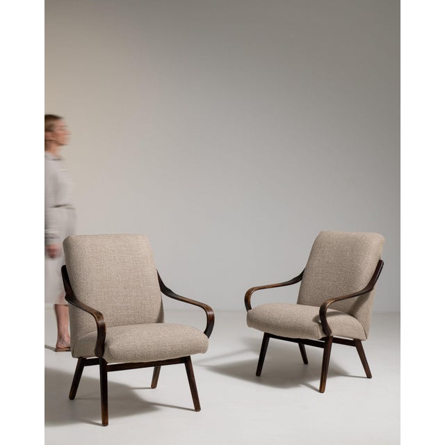 Here is a pair of armchairs, its taupe upholstery, dark wood angled legs the first thing to catch the eye. Originating in...