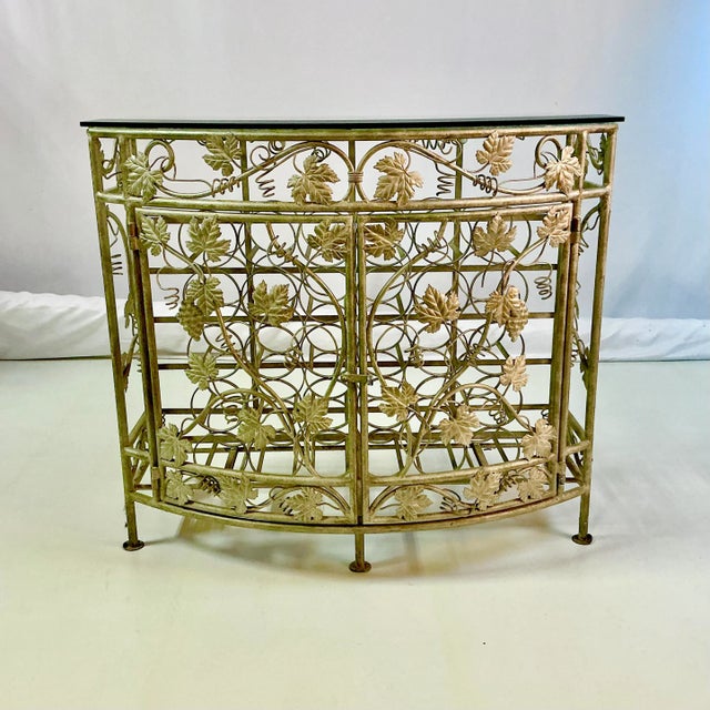 A stunning metal Silver Leaf finished 30-Well Wine Rack Console Table with a beveled glass top. The table has lost its...