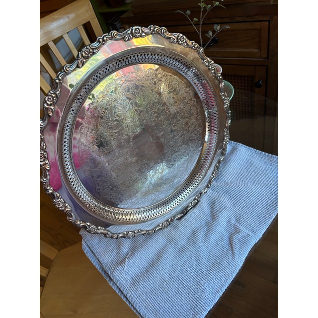 Add a touch of classic elegance to your home with this beautiful vintage round silver-plated serving tray made by Oneida...