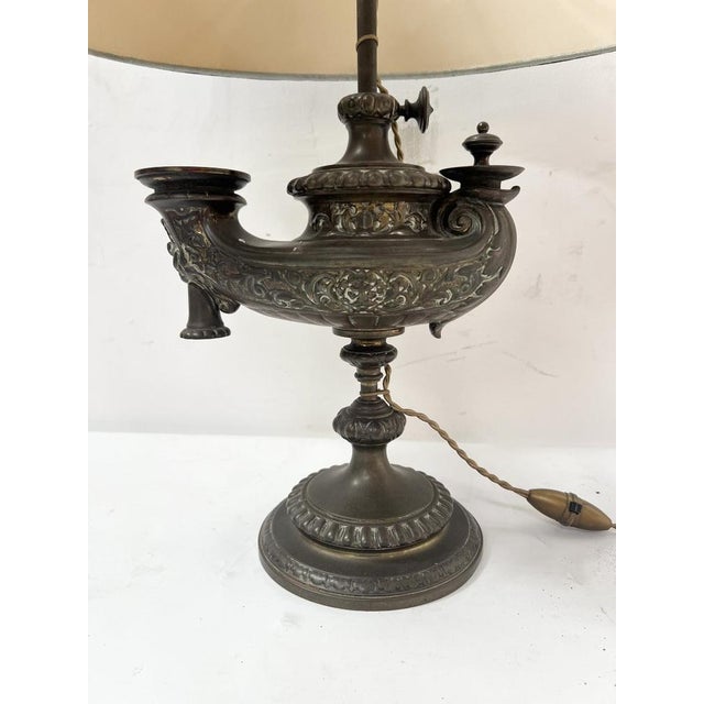 Old oil lamp on a patinated bronze shower stand Model decorated with gadroons and acanthus leaves Lamp mounted on...