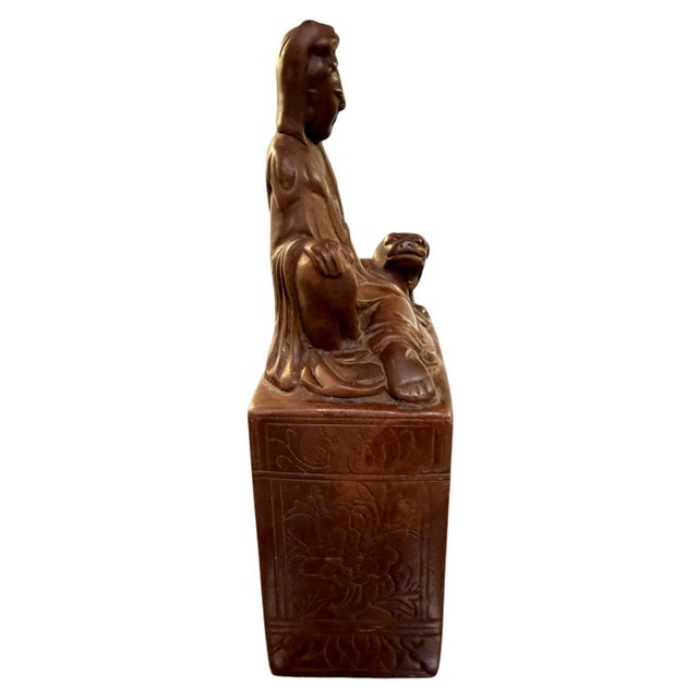 Antique Chinese hand-carved soapstone sculpture depicting Guanyin, the Bodhisattva of Compassion, seated beside a Foo Dog...
