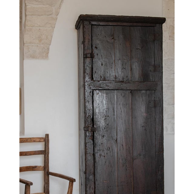 A dark Portuguese cabinet dating back to the late 19th/early 20th century with two doors and internal shelves. The piece...