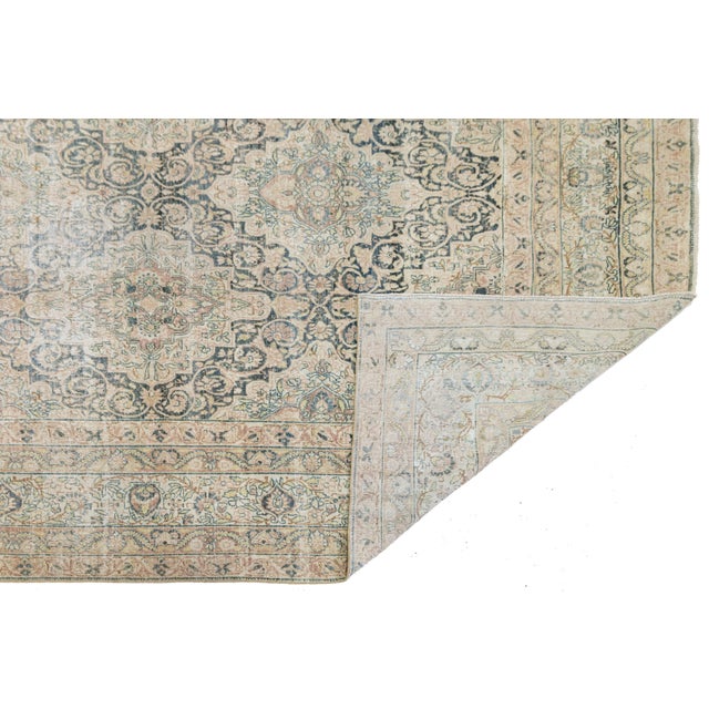 This authentic antique Kerman rug features a refined medallion layout with intricate floral motifs in muted beige, blue,...
