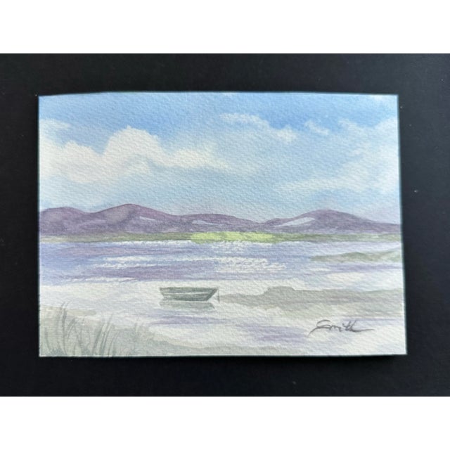 A boat in the water with purple hills in the background. Signed and ready to frame. Nancy Smith studied art at Kalamazoo...