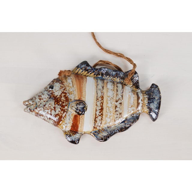 A trio of mid-century French majolica fish wall plaques from Vallauris, hand-glazed in gorgeous tones of blue, brown, and...