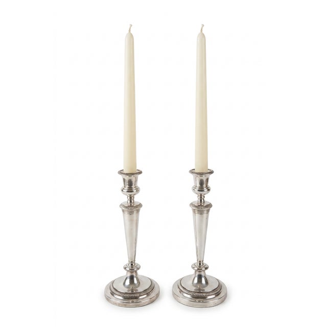 An elegant pair of silverplate two-arm candelabra featuring a versatile convertible design that allows the pieces to be...