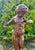 An elegant cast iron garden statue depicting a little girl watching a butterfly perched on her hand. A scene full of...