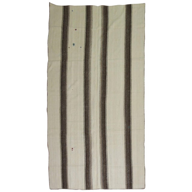 A vintage Turkish kilim with a striped motif in browns and cream.