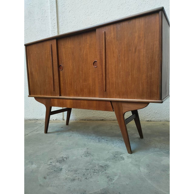 Elegant wooden sideboard with a classic and functional design. – Sliding doors with round handles. – Tapered legs provide...