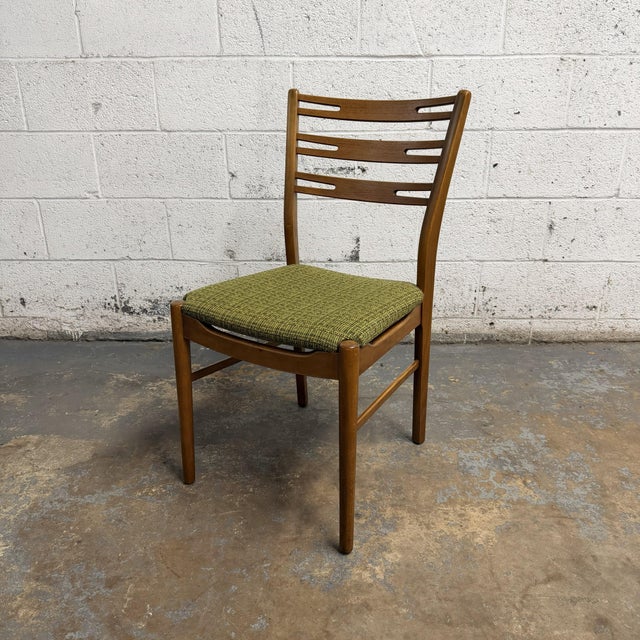 A set of four vintage Danish teak dining chairs by Farstrup, Model 219. The chairs have tall curved backs with horizontal...
