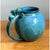This pottery jug takes a full, rounded silhouette, its bulbous body swelling generously outward before curving inward to a...