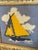 Charming vintage needlepoint depicting a classic sailboat gliding across the water beneath billowing white clouds. The...