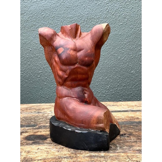 This wood sculpture presents a fragmented male torso, carved with confident anatomical precision from a single block of...