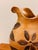 Glazed ceramic jug in a warm honey-brown tone, adorned with organic floral and vegetal motifs in relief and incision,...