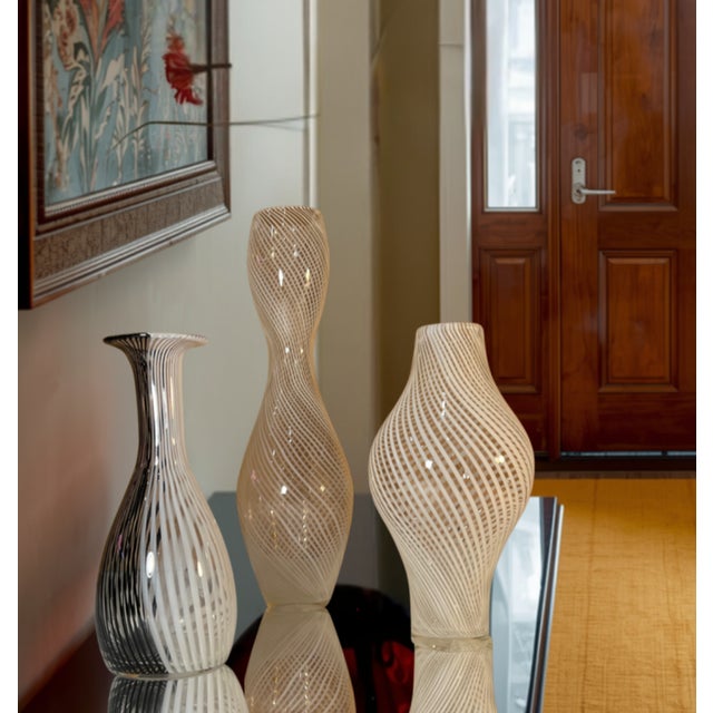 Three mid‑century hand‑blown Murano glass vases, each with an elegant organic silhouette and crafted using the Venetian...