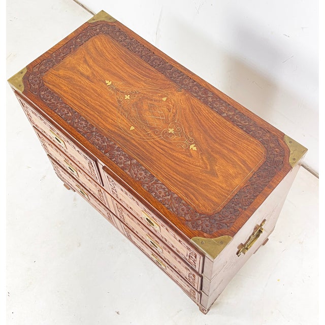 A small rosewood or “sheesham”brass boundcampaign style jewelry chest from the mid 20th century, decorated with relief...