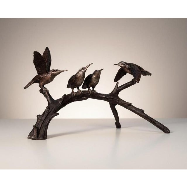 Charming bronze sculpture depicting four hummingbirds arranged upon a naturalistic tree branch Two birds are shown perched...