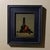 The composition features a striking still life with a dark green bottle, a vibrant red Anjou pear, and clusters of deep...