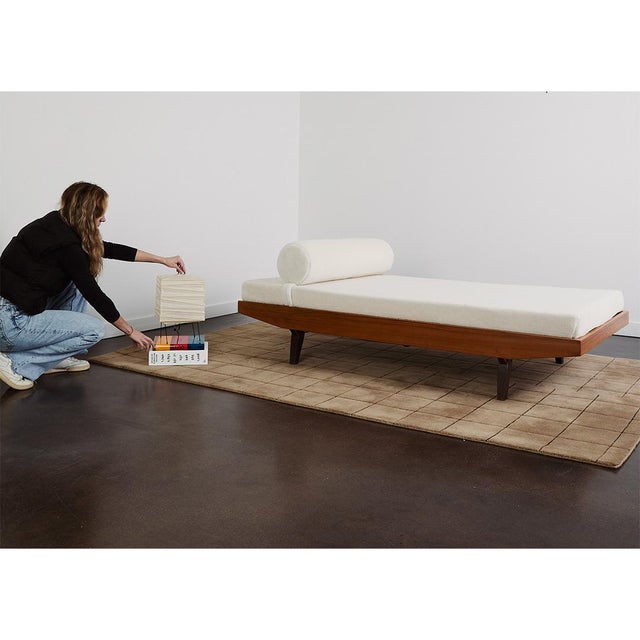 An Italian daybed attributed to Augusto Romano from the 1950s with a solid wood frame, tapered legs, and a low,...