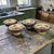 The product is a set of four Certified International Pamila Gladding Rustic Tuscan Landscape bowls, made of ceramic and...