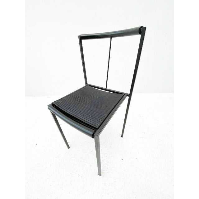 The chairs have a matte black metal frame with four square-section legs, the backs of which extend to the entire backrest....
