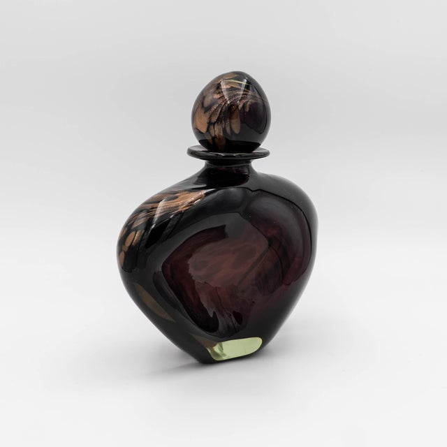 An exquisite statement piece, this hand-blown art glass perfume bottle showcases a dramatic silhouette and masterful...